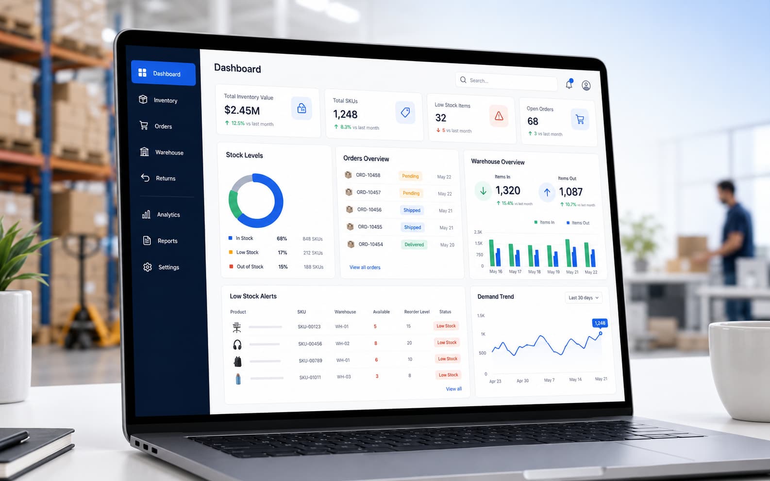 Inventory management software dashboard on a laptop showing stock levels, orders, warehouse activity, low-stock alerts, and demand trends.